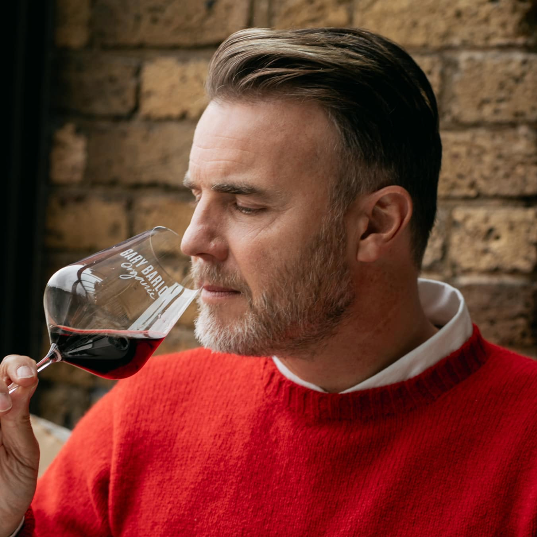 Gary Barlow savoring the aroma of his Red Wine in a Gary Barlow Wine Glass, embodying elegance and rich flavors.